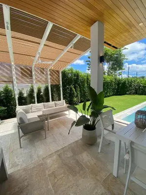 a patio with white furniture and a wooden ceiling at Minimalist luxury villa in Ban Klang