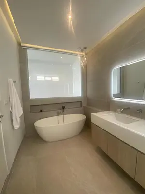 a bathroom with a large white tub and a sink at Minimalist luxury villa in Ban Klang