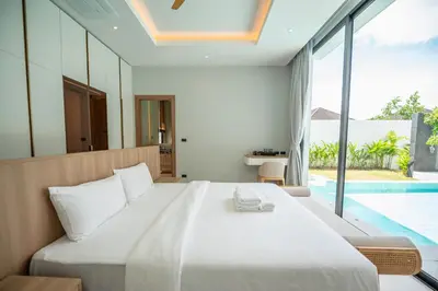 a bedroom with a large bed and a swimming pool at Mouana Residence Song Khun Chalong 4-bedroom Pool Villa 896 in Chalong