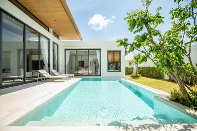 an infinity pool in the backyard of a house at Mouana Residence Song Khun Chalong 4-bedroom Pool Villa 896 in Chalong