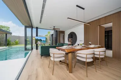 a dining room with a table and chairs next to a swimming pool at Cocoon Villa 5 - Luxurious 3BR Pool Retreat near Naithon Beach in Nai Thon Beach