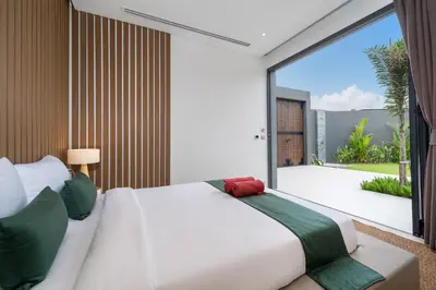 a bedroom with a white bed and a large window at Cocoon Villa 5 - Luxurious 3BR Pool Retreat near Naithon Beach in Nai Thon Beach