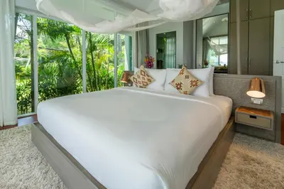 a bedroom with a large white bed with a large window at Coastal Escape Koh Yao Noi in Ko Yao Noi
