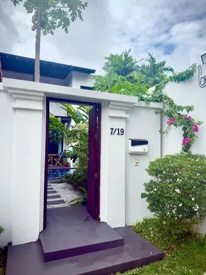 a white house with a red door at Phuket Hideaway Near Bang Tao in Laguna Phuket