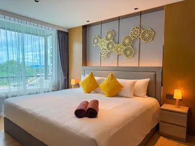 a bedroom with a large bed with two shoes on it at La Vita Rawai Nai Harn Beach 5 Star 1 BDR in Rawai Beach
