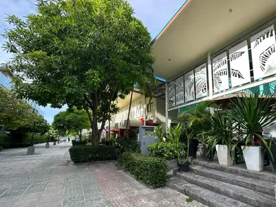 a building with trees and plants in front of it at By the Beach Hostel in Phi Phi Don