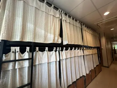 a row of white curtains in a room at By the Beach Hostel in Phi Phi Don