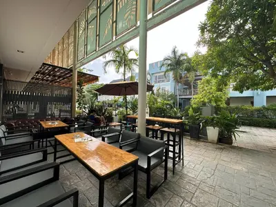 a restaurant with tables and chairs and an umbrella at By the Beach Hostel in Phi Phi Don