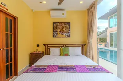 a bedroom with a bed and a large window at V225 Spacious 3BR Villa Pool and Garden Near Beach in Rawai Beach