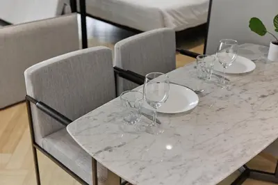 a marble table with wine glasses on top of it at Title Legendary, 1-BR, 45 sqm, 8 min to BangTao Beach in Bang Tao Beach