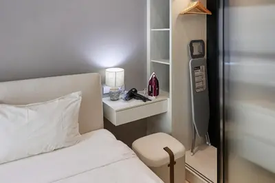 a bedroom with a bed and a chair and a nightstand at Title Legendary, 1-BR, 45 sqm, 8 min to BangTao Beach in Bang Tao Beach