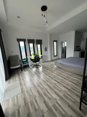 a bedroom with a bed and a desk and chairs at Vista Loft Bang Tao in Ban Thalat Choeng Thale