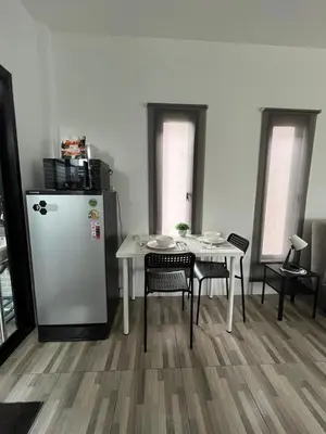 a dining room with a table and a refrigerator at Vista Loft Bang Tao in Ban Thalat Choeng Thale