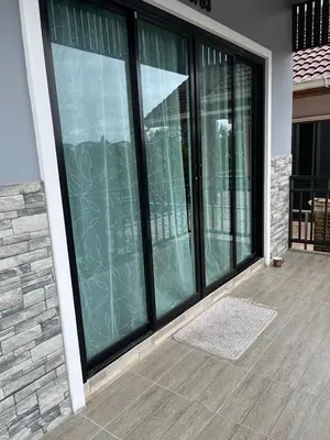 a screened in porch with glass doors on a house at Vista Loft Bang Tao in Ban Thalat Choeng Thale