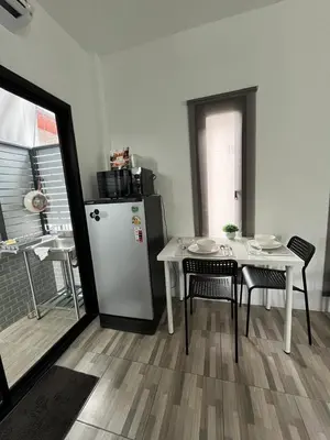 a kitchen with a white table and a refrigerator at Vista Loft Bang Tao in Ban Thalat Choeng Thale