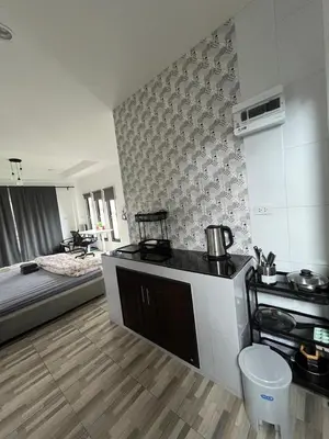 a kitchen with a stove and a bed in a room at Vista Loft Bang Tao in Ban Thalat Choeng Thale