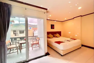a hotel room with a bed and a balcony at A&N Residence Patong in Patong Beach