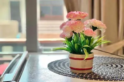 a vase filled with pink flowers sitting on a table at A&N Residence Patong in Patong Beach