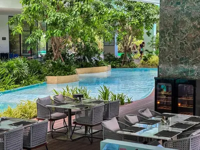 a restaurant with a pool with tables and chairs at New Modern 1Bdr Laya 500 m to the Beach in Layan Beach