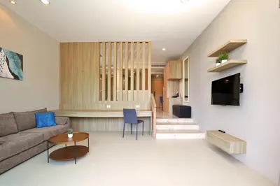 a living room with a couch and a table at Spacious studio with access to the pool in Karon Hill condo in Karon Beach