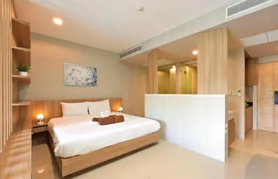 a bedroom with a large white bed in a room at Spacious studio with access to the pool in Karon Hill condo in Karon Beach