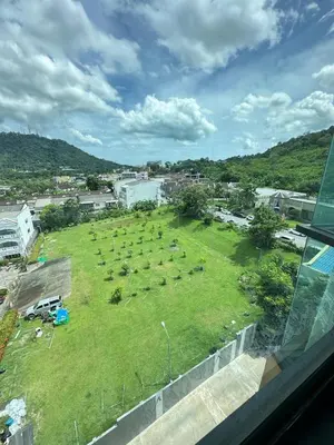 a large grassy field with animals in a city at The Base Height in Phuket Town