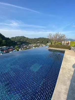 a swimming pool with blue tiles on the water at The Base Height in Phuket Town
