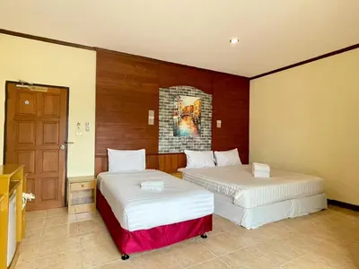 two beds sitting in a room with a door at Maap Guest House in Patong Beach