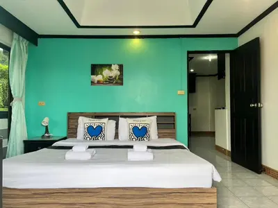 a bedroom with a large bed with a blue wall at NR Nanai Patong in Patong Beach