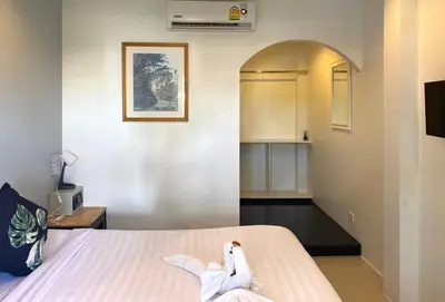 a bedroom with a bed with a bird sitting on it at NR Nanai Patong in Patong Beach