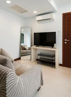 a living room with a television and a couch at Relaxing Apartment in Karon in Karon Beach