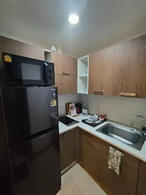 a kitchen with a black refrigerator and a sink at Relaxing Apartment in Karon in Karon Beach