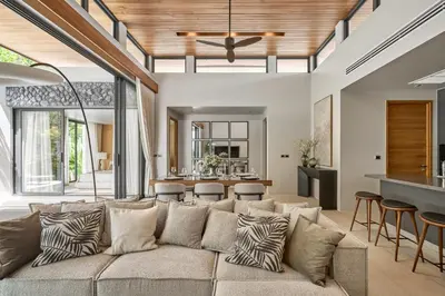 a living room with a large couch and a kitchen at Premium Villa Botanica 3-BR with Pool and Garden in Ban Pak Lak