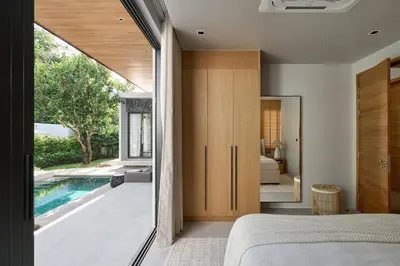 a bedroom with a view of a swimming pool at Premium Villa Botanica 3-BR with Pool and Garden in Ban Pak Lak