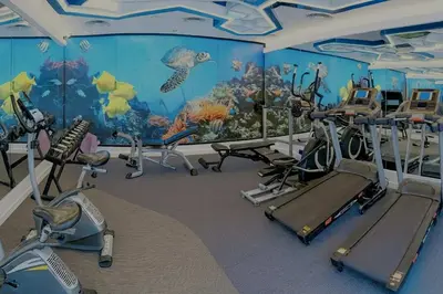 a gym with an aquarium themed room with exercise bikes at Stay Kata in Kata Beach