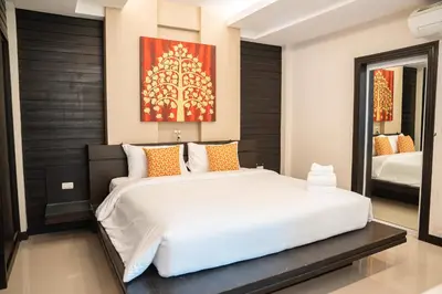 a bedroom with a large white bed and a mirror at Lulu Hotel at The Glasshouse Lion Café in Ban Sire