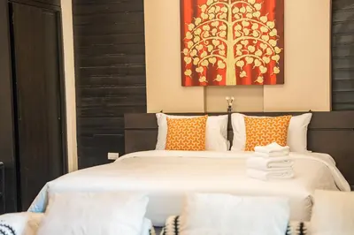 a bedroom with a large bed with orange pillows at Lulu Hotel at The Glasshouse Lion Café in Ban Sire