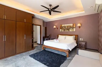 a bedroom with a bed and a ceiling fan at 6 Bedroom Villa Sri Suri with Private Pool and Butler service near Nai Harn Beach in Rawai Beach