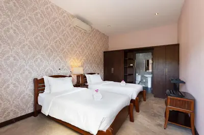 two beds in a hotel room with white sheets at 6 Bedroom Villa Sri Suri with Private Pool and Butler service near Nai Harn Beach in Rawai Beach
