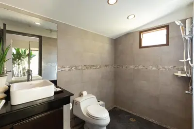 a bathroom with a toilet and a sink at 6 Bedroom Villa Sri Suri with Private Pool and Butler service near Nai Harn Beach in Rawai Beach