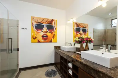 a bathroom with two sinks and a large mirror at 6 Bedroom Villa Sri Suri with Private Pool and Butler service near Nai Harn Beach in Rawai Beach