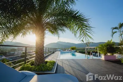 a palm tree on a balcony with a pool at Modern Apartment in Chalong in Chalong