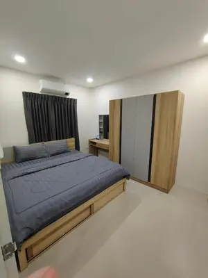 a bedroom with a bed and a mirror at The White House Chalong in Chalong