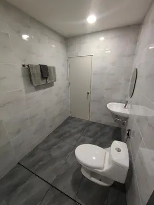 a bathroom with a white toilet and a sink at The White House Chalong in Chalong