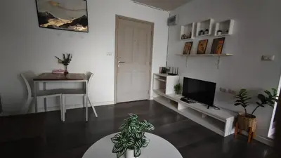 a living room with a table and a television and a desk at D Condo mine Kathu in Kathu