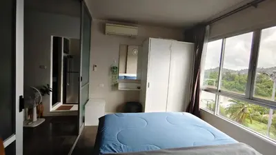 a bedroom with a blue bed and a window at D Condo mine Kathu in Kathu