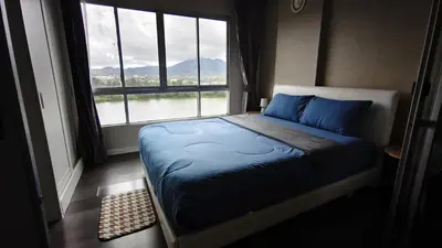 a bed in a room with a large window at D Condo mine Kathu in Kathu