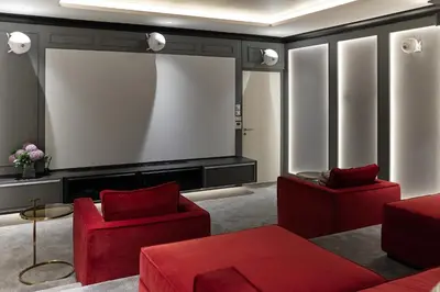 a living room with red furniture and a large screen at Brand New apartments, 60 sqm, BangTao beach in Bang Tao Beach