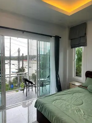 a bedroom with a bed and a view of a balcony at Villa Sea View PanWa in Ko Taphao Noi