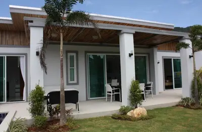 a house with a porch with chairs and tables at Villa with private pool in Kamala in Kamala Beach